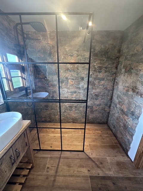 Exposed brick wet-room with crittall shower enclosure