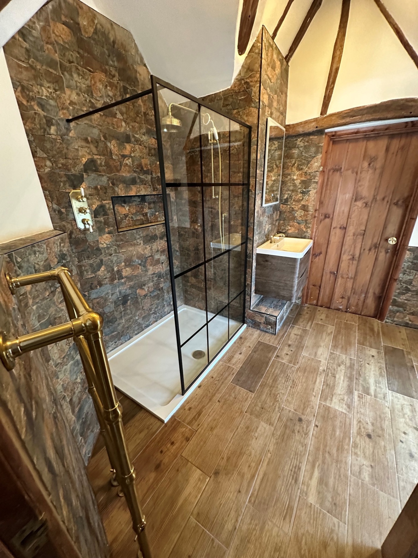 Beamed cottage wet-room with crittall screen, stone walls & brass shower