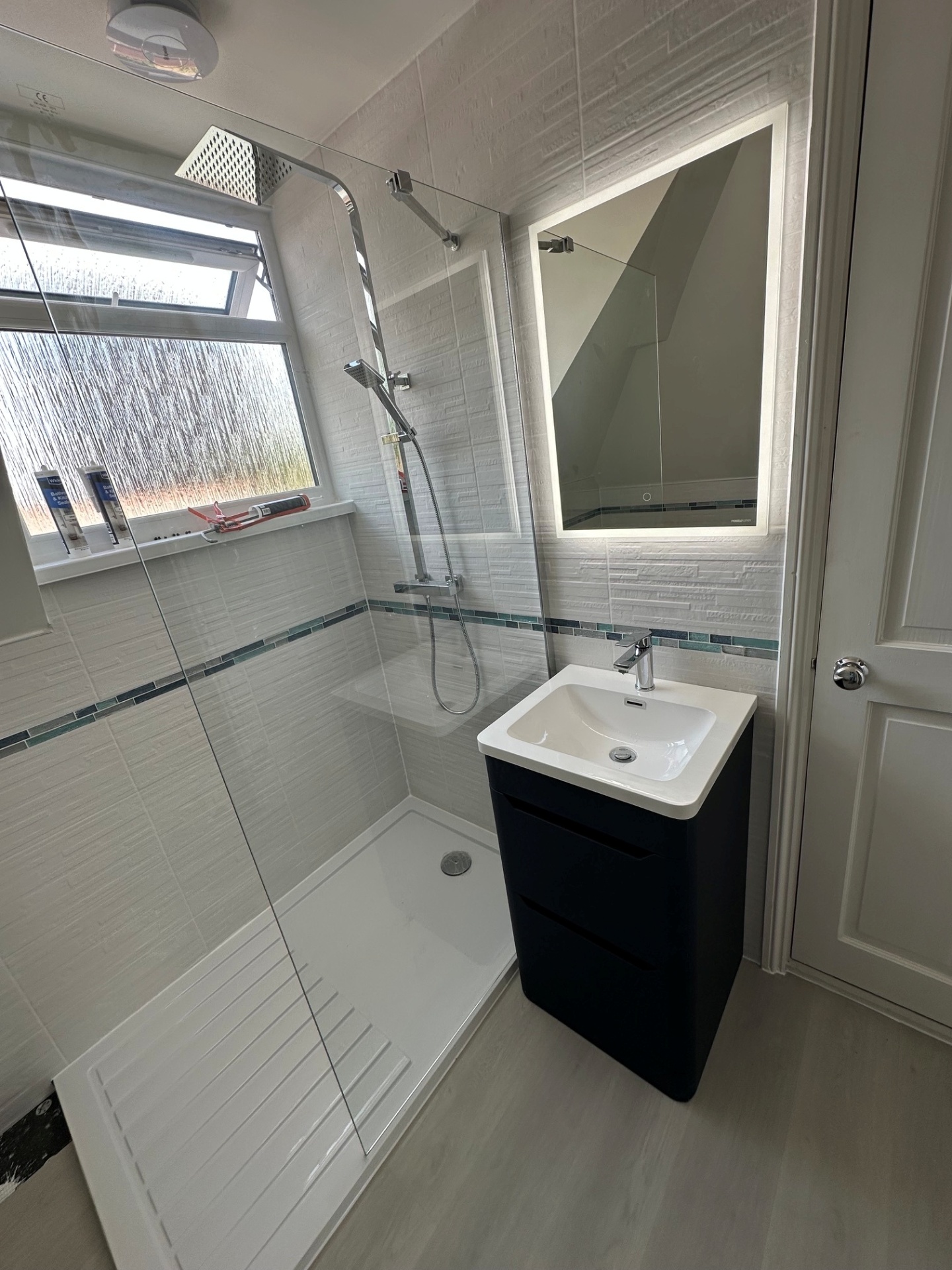 Dated white bathroom → sleek walk-in shower with black vanity & LED mirror — after