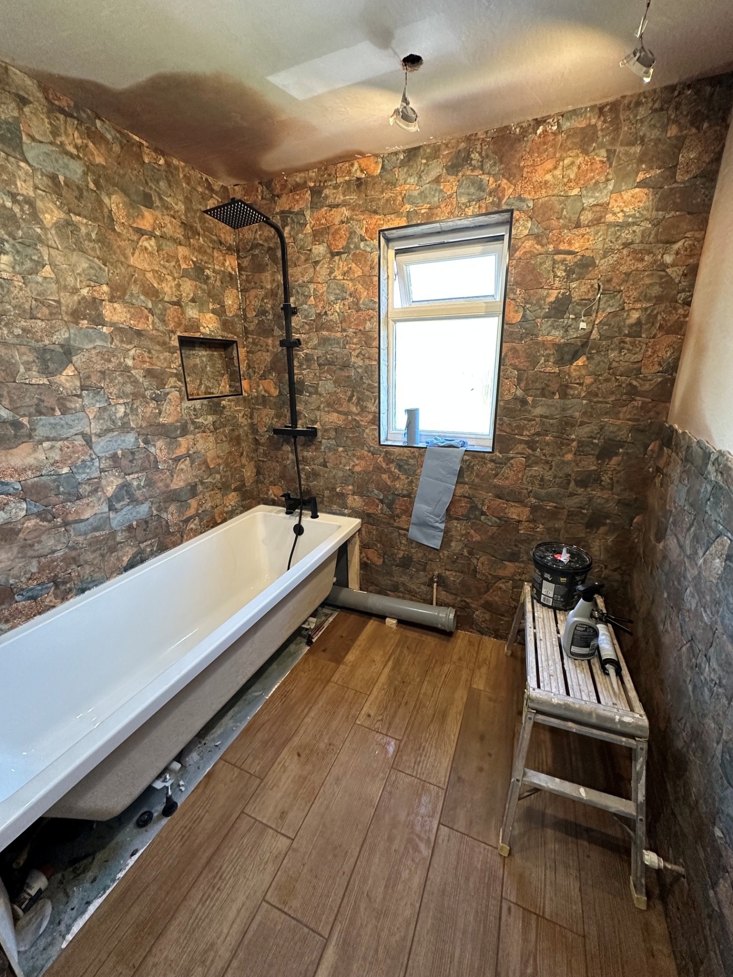 Bath installation with feature stone tiling & matt black fittings