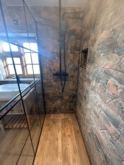 Stone-wall wet-room with thermostatic shower & wood-effect floor